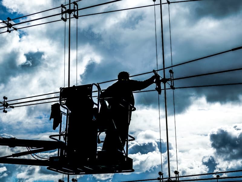 Operatore professionale che pulisce vetrate di un edificio commerciale con asta telescopica